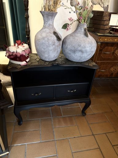 Pappmaché-Vasen „Stone Look“ Schwarzer Kommode mit zwei Schubladen, flanked by zwei große graue Vasen.